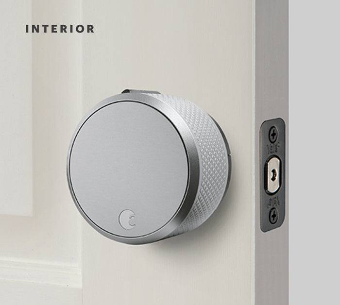 A silver August wifi lock on an open door