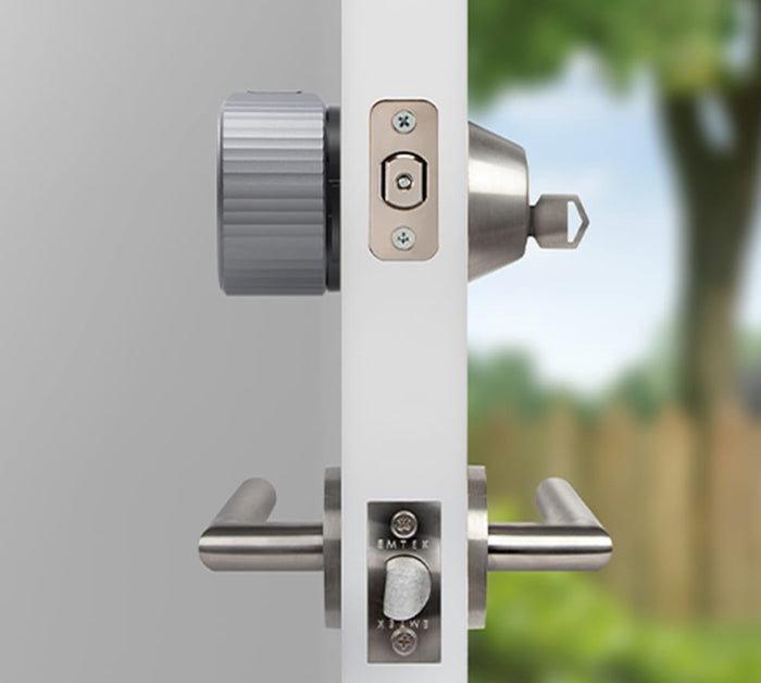 The side view of a silver august lock on a door with a key in the lock