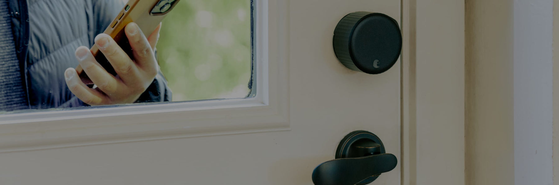 August smart lock pro in dark gray shown with a lever handle on the interior of a door