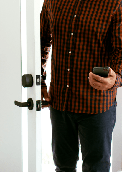A man entering a door with his smartphone