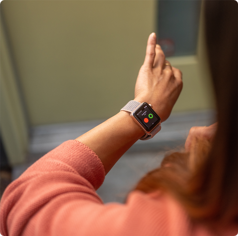 A woman checks the status of her wifi smart lock on her smartwatch