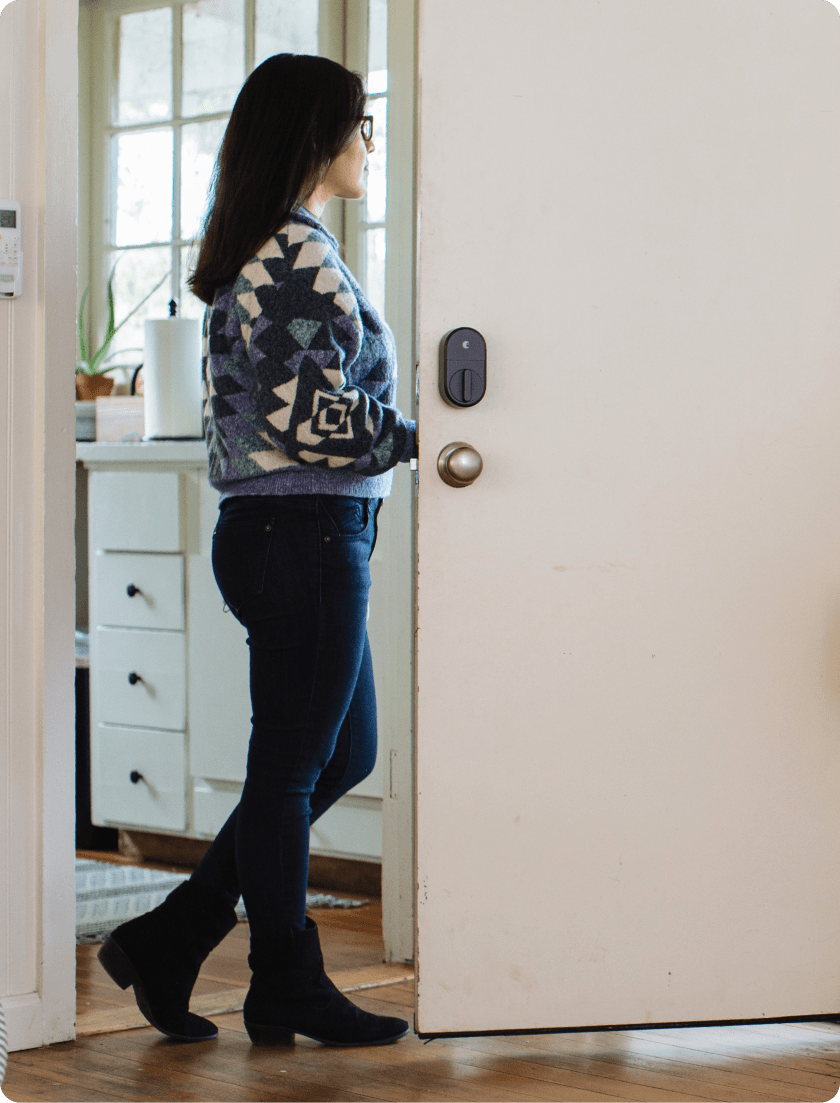 Woman opening the front door with an August smart lock