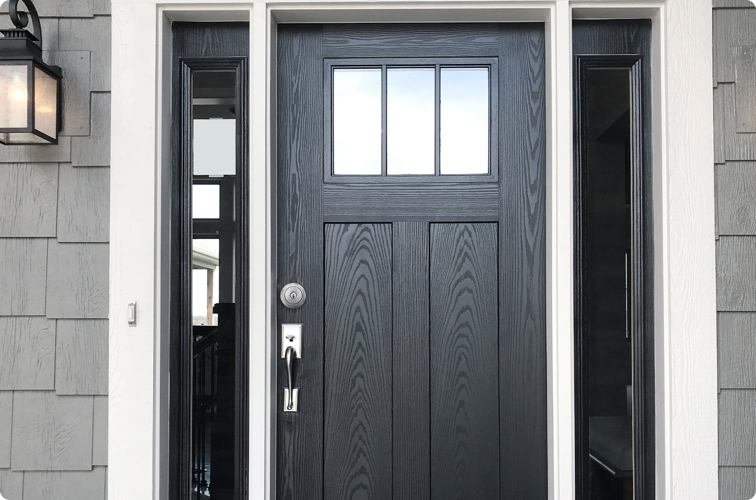 A closed front door made of black wood with a silver lock 