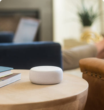 A man relaxes in his living room with a google nest smart speaker