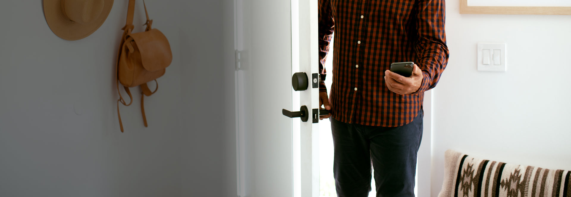 A man opening his door with the August smartphone app
