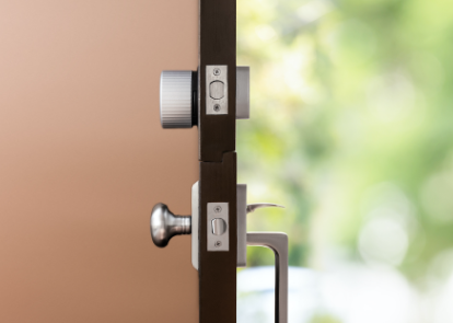 A side view of a silver August wifi lock installed on a door