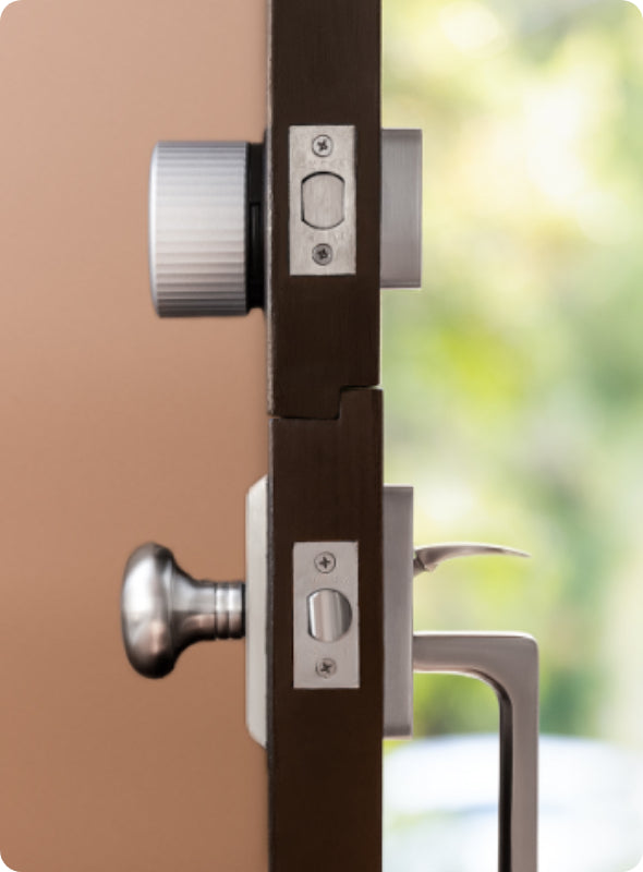 The side view of a silver August lock installed on a black door